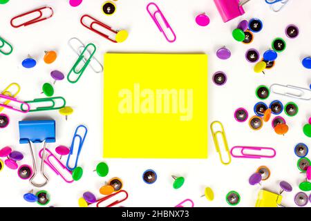 Helles pinkes, gelbes, blaues und grünes Schreibwarenzubehör für Büro und Bildung auf weißem Hintergrund mit Platz für Haftnotizen. Stockfoto
