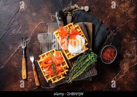 Waffle Sandwich mit Frischkäse, geräuchertem Lachs, Ei und rotem Kaviar. Dunkler Hintergrund. Draufsicht Stockfoto