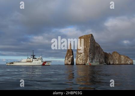 USCGC Mohawk (WMEC 913) und die Ecuador Navy LAE Isla San Cristobal (LG 30) überqueren am 28. November 2021 auf den Galapagos-Inseln die Gesteinsformation Sleeping Lion auf See. Der berühmte Mittelausdauerschneider kehrte am Sonntag nach einem bahnbrechenden 45-tägigen Einsatz im Ostpazifik in den Heimathafen von Key West zurück Foto der Küstenwache von USCGC Mohawk) Stockfoto