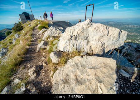 Lovcen, Montenegro-September 14 2019: Wenn die Sonne untergeht, wandern Touristen vom Gipfel des Mount Lovcen, um Treppen in den Tunnel hinunterzusteigen, vorbei an der Durchfahrt Stockfoto