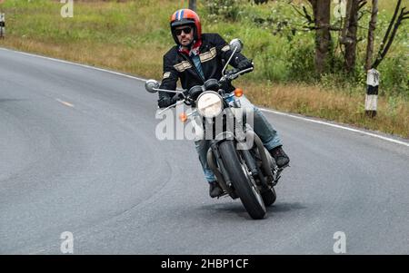 Mann auf seinem klassischen Motorrad im Khao Yai Nationalpark Stockfoto