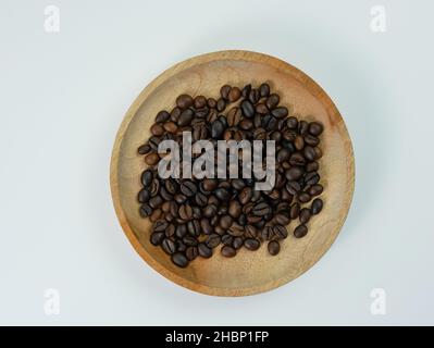 Hochwertige Kaffeebohnen auf Holzplatte isoliert auf weißem Hintergrund Stockfoto