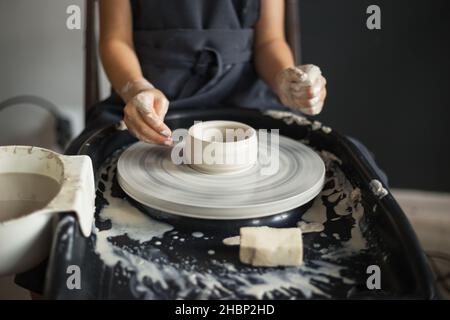 Mädchen Hände arbeiten mit Ton auf einem Potter's Rad Nahaufnahme. Tradi Stockfoto