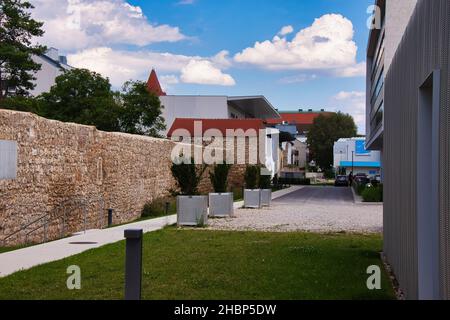 WIENER NEUSTADT, ÖSTERREICH - 27. Jul 2020: Blick von außen auf die alte Mauer mit dem neuen Hilton Hotel auf der rechten Seite neben dem Stadtpark Stockfoto