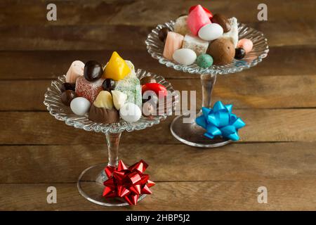 Traditionelle türkische Mixed-Süßigkeiten, Schokolade und Köstlichkeiten in einer stilvollen Glas-Süßigkeitenschale auf einem Holztisch Stockfoto