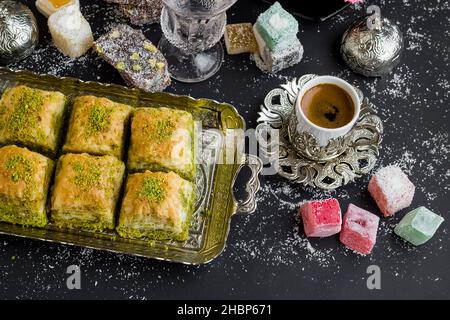 Traditionelle türkische Konditorei Pistachio Dry Baklava, auf Vintage-Tablett mit Kaffee und Köstlichkeiten.konzeptionelles Bild von Feiern. Stockfoto