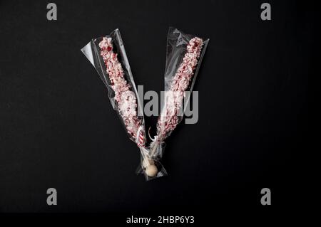 Zwei zerkleinerte Candy-Cane-Sticks isoliert auf dem schwarzen Hintergrund Stockfoto