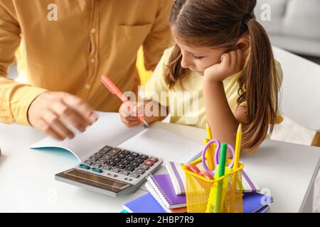 Mann hilft seiner kleinen Tochter, zu Hause Unterricht zu machen Stockfoto