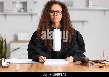 Weibliche Richterin sitzt am Arbeitsplatz im Gerichtssaal Stockfoto