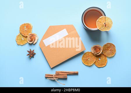 Umschlag mit Gewürzen und einer Tasse Tee auf farbigem Hintergrund Stockfoto