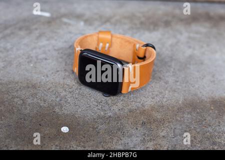 Hellbraunes braunes Lederuhrarmband Handarbeit auf Holz Stockfoto