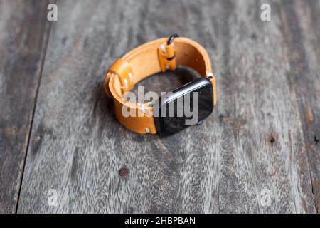 Hellbraunes braunes Lederuhrarmband Handarbeit auf Holz Stockfoto