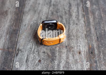 Hellbraunes braunes Lederuhrarmband Handarbeit auf Holz Stockfoto