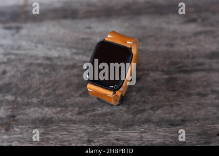 Hellbraunes braunes Lederuhrarmband Handarbeit auf Holz Stockfoto