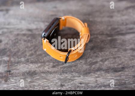 Hellbraunes braunes Lederuhrarmband Handarbeit auf Holz Stockfoto