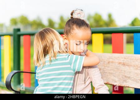 Junge auf dem Rücken kuschelt und entschuldigt sich bei seiner Schwester Stockfoto