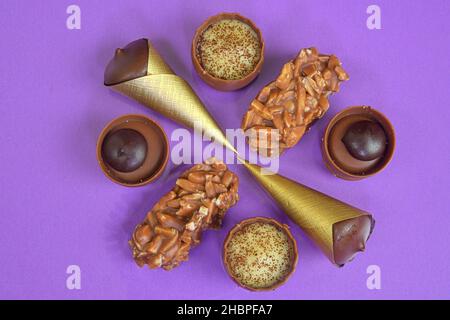 Pralinen-Pralinen auf pastellfarbenem Hintergrund mit Copyspace. Auswahl an feinen Schokoladen-Bonbons, weißer, dunkler und Milchschokolade. Süßigkeiten Stockfoto