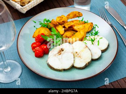 Im Landhausstil gebackene Merluccius-Steaks mit Kartoffeln Stockfoto