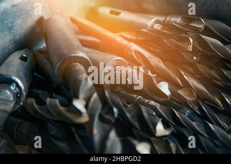 Gebrauchte Bohrer auf Metall Nahaufnahme. Satz von Stahlbohrern in der Drehwerkstätte. Hintergrund. Stockfoto