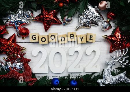 Auf Wiedersehen 2022 Buchstaben und weihnachtsschmuck auf Holzhintergrund Stockfoto