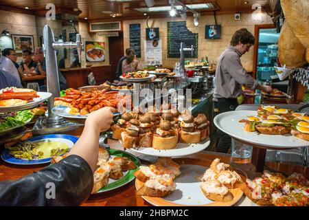 Tapas Pinchos oder Pintxos werden in einer Bar in Donostia San Sebastian, Gipuzkoa, Baskenland, Spanien, serviert Stockfoto