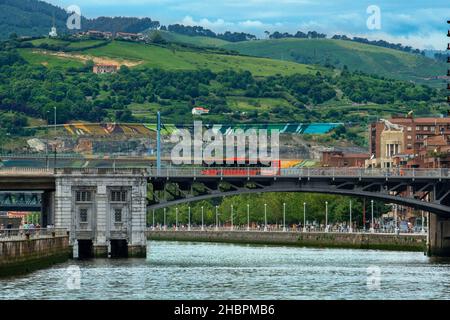 Deusto-Brücke in Bilbao, Spanien an einem sonnigen Tag mit grünen Hügeln im Zentrum von Bilbao, Nordspanien. Stockfoto