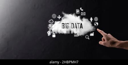 Geschäftsmann hält die Inschrift , Wort BIG DATA . Vorhängeschloss, Gehirn, Mann, Planet, Graph, Lupe, Zahnräder, Symbol für Cloud, Grid, Dokument, Brief, Telefon Stockfoto