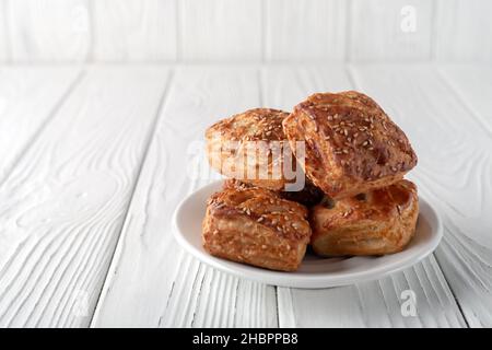 Mini Blätterteig gefüllt mit Huhn und Pilzen auf weißem Holzhintergrund Stockfoto