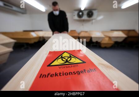 Ulm, Deutschland. 10th Dez 2021. Ein Mitarbeiter des Ulmer Krematoriums schiebt den Sarg einer mit Covid-19 verstorbenen Person. Quelle: Marijan Murat/dpa/Alamy Live News Stockfoto