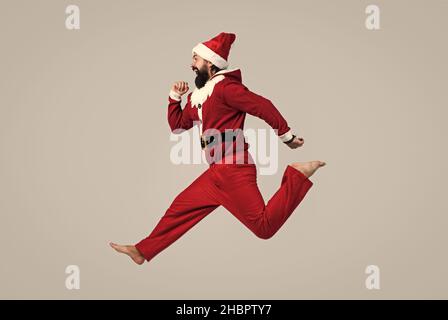 Frohe Feiertage. santa ctlaus in Hut beeilen Sie sich bis zu Weihnachten Shopping-Verkäufe. Running bärtigen Mann in weihnachten Kostüm. Konzept der Freiheit. Happy Male hat lustig Stockfoto