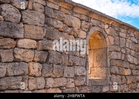 Teil einer alten Steinmauer mit einem gewölbten Fenster, das sich im archäologischen Museum von Chersonesos öffnet Stockfoto