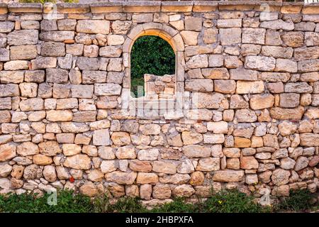 Teil einer alten Steinmauer mit einem gewölbten Fenster, das sich im archäologischen Museum von Chersonesos öffnet Stockfoto