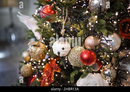 Schöne traditionelle Weihnachtsdekorationen und Lichter rote Kugeln Kieferntanne Zweige. Weihnachtsbeleuchtung für die Weihnachtszeit. Stockfoto