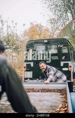 Vater und Sohn schleppen Anhänger in Richtung Sport Utility Vehicle Stockfoto