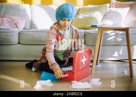 Fokussierte Tierärztin mit Verbandskasten im Wohnzimmer Stockfoto