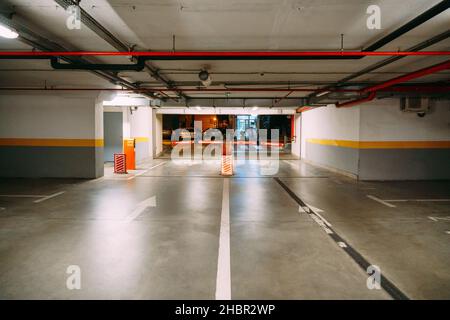 Ausgang mit einer Schranke von einem großen beheizten Tiefgaragenparkplatz Stockfoto