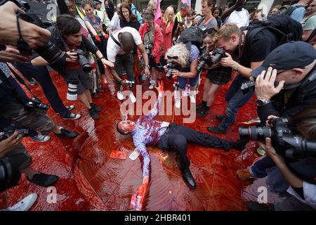 Rückblick auf das Jahr 2021. Aktenfoto vom 27/08/21 eines Mitglieds der Extinction Rebellion, das in gefälschtem Blut auf dem Phernoster Square im Zentrum von London herumrollt. Ausgabedatum: Dienstag, 21. Dezember 2021. Stockfoto