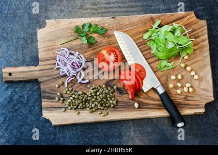 Frisch geschnittenes Gemüse auf einem Schneidebrett mit einem Kochmesser Stockfoto