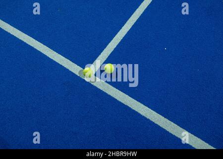 Blauer Paddle-Tennisplatz in der Nacht und zwei Kugeln auf der Linie. Schlägersportkonzept, gesunder Sport. Stockfoto