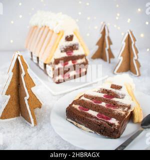 Kuchen - Weihnachtshütte. Biskuitkuchen mit Sahnecreme mit Zusatz von Kirschen. Stockfoto