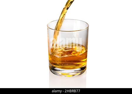 Whisky, Whiskey oder Bourbon, die in Whiskyglas auf weißem, kopiertem Raum einströmen Stockfoto