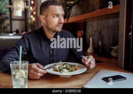 Der junge Geschäftsmann hat im Restaurant zu Mittag gegessen Stockfoto