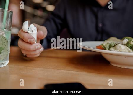 Nahaufnahme der Mann hört Musik, während er im Restaurant zu Mittag gegessen hat Stockfoto
