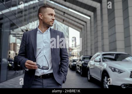 Erfolgreicher junger Geschäftsmann im Anzug auf der Straße Stockfoto