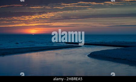 Stony Creek fließt bei Sonnenuntergang in den Lake Michigan, im Benona Township Park, Shelby, Michigan. Stockfoto