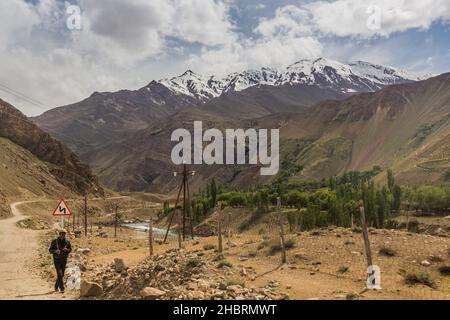 WAKHAN-TAL, TADSCHIKISTAN - 22. MAI 2018: Einheimischer geht auf einer Straße im Wakhan-Tal zwischen Tadschikistan und Afghanistan Stockfoto