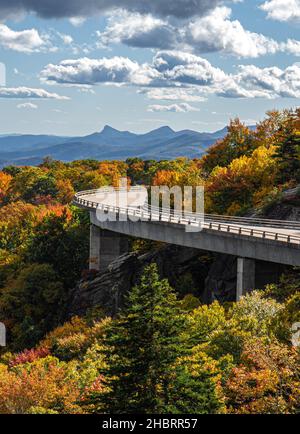 Eine vertikale Aufnahme einer von bunten Bäumen umgebenen Brücke im Großvater Mountain State Park Stockfoto