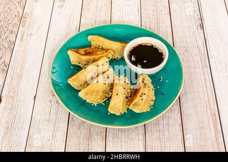 Japanische Gyozas oder Knödel werden auf dem Weg zum Mund in Sauce getaucht. Unsere besteht aus einer Mischung aus Reisessig und Sojasauce Stockfoto