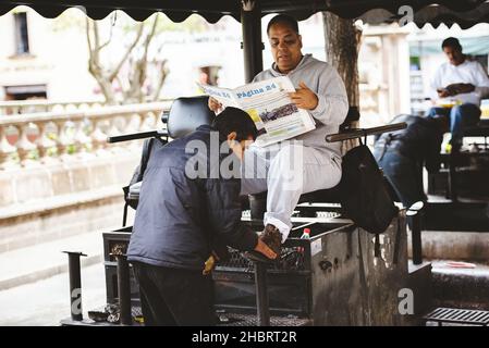 ZACATECAS, MEXIKO - 01. Apr 2018: Ein mexikanischer Mann, der seine Schuhe in der Stadt Zacatecas, Mexiko, glänzt Stockfoto