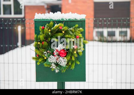 Heimische Briefkasten mit Fichtenbaum Weihnachtskranz im Freien in verschneiten Wintertag dekoriert. Urlaubsstimmung. Stockfoto